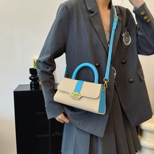 Modische beige-königsblaue Box-Tasche mit Logo in Goldoptik und praktischem Schultergurt