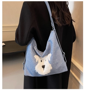 Détail du sac cabas en denim bleu avec motif chiot en peluche 3D et bandoulière réglable