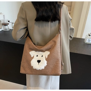 Detail of canvas tote bag featuring plush schnauzer dog applique and adjustable strap