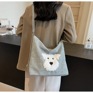 Détail du sac bandoulière gris avec broderie chien pelucheux blanc et large bandoulière