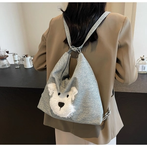 Sac fourre-tout en denim bleu avec tête de chien en peluche blanche sur une tenue chic