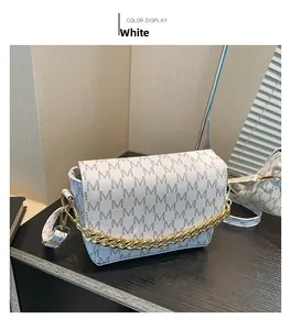 Detail of white monogram flap bag with gold chain strap and M pattern print