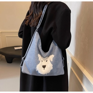 Détail du sac cabas en denim bleu clair avec broderie de chien schnauzer en peluche