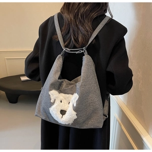 Close-up of a grey fabric tote bag featuring a cute white plush puppy applique detail