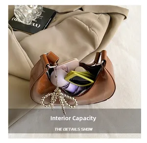 Detail showing internal capacity of the brown leather crescent bag with daily essentials