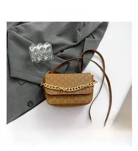 Detail of brown monogram shoulder bag featuring M-pattern and gold chain decoration
