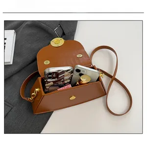 Detailansicht der Kapazität einer braunen Krokodilmuster-Box-Tasche mit zwei Telefonen