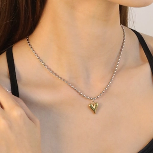 Collana con ciondolo a cuore minimalista dorato e catena a sfere d'argento al collo