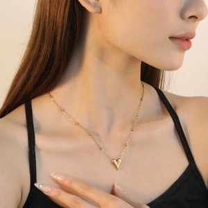 Collana con ciondolo a cuore d'oro minimalista su modella con catena a perline