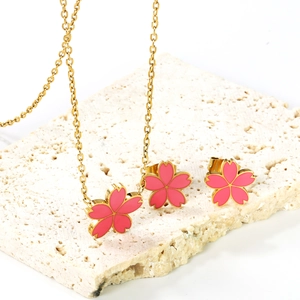 Dettaglio del set di gioielli con fiori di ciliegio in smalto rosa su pietra