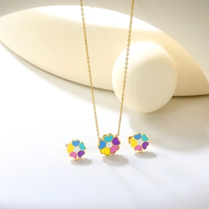 Dettaglio della collana placcata oro 18k e orecchini a fiore su oggetti decorativi minimali