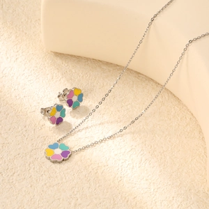 Dettaglio macro della collana e degli orecchini a fiore smaltato arcobaleno