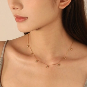 Gold eight-pointed star necklace with airplane pendants on a female model