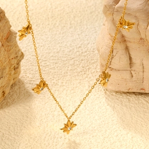 Macro shot of gold star necklace with inlaid crystals on textured natural stones