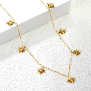 Detail of gold star pendant necklace with cubic zirconia on white geometric stand