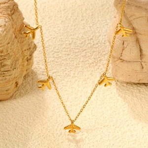 Golden stainless steel necklace featuring five delicate small airplane pendants on a stone