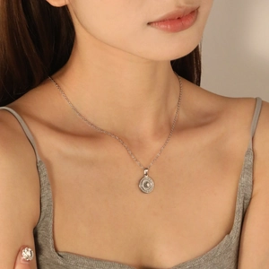Collier minimaliste en acier inoxydable avec pendentif soleil porté par un mannequin