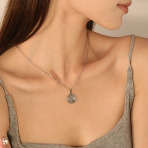 Collier argenté avec pendentif boussole solaire ronde sur une fine chaîne en acier