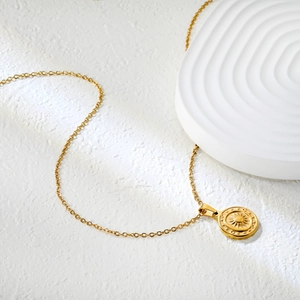 Détail du pendentif soleil en acier plaqué or 18K sur une fine chaîne dorée