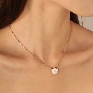 Collier en acier inoxydable doré 18 carats avec pendentif fleur en nacre porté par un mannequin