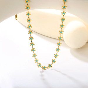 Collier en acier inoxydable plaqué or 18 carats avec fleurs bleues sur support