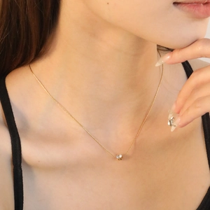 Collana minimalista in oro con pendente in zircone bianco incastonato a griffe su modella