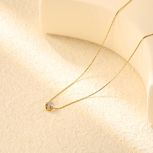 Primo piano di un'elegante collana in acciaio inossidabile dorato con zircone rotondo