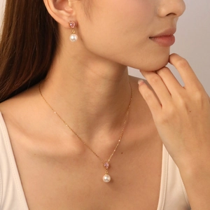 Elegant gold necklace and teardrop pink crystal pearl earrings set worn by model