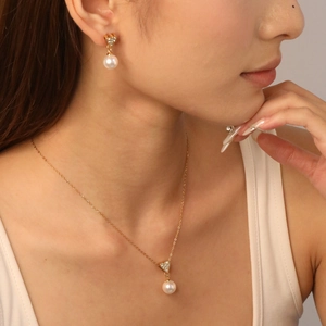 Elegant gold stainless steel pearl jewelry set with zircon heart pendant on female model