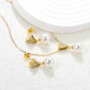 Macro detail of gold heart earrings and necklace set with pavé zircon and white pearls