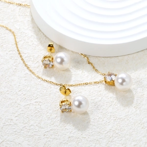 Detailed view of zircon and pearl jewelry set with heart studs and matching necklace