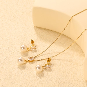 Detailed set of gold-plated necklace and heart earrings with pearls and zircons