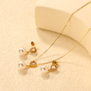 Detailed view of the gold heart jewelry set with zircon and pearls on a sleek display