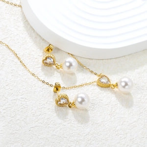 Detailed view of heart zircon and pearl pendant necklace with matching earrings set