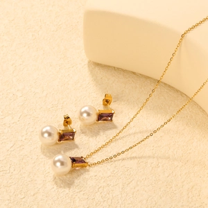 Detail of gold-plated necklace and heart earrings with pearls and purple zircon stones
