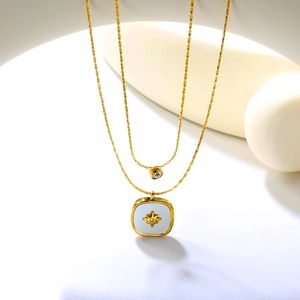 Detail of 18K gold-plated double-layer necklace featuring starburst pendant and zircon