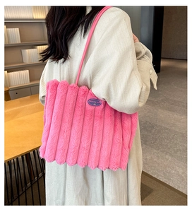 Detail of pink plush tote bag showing vertical stripes and blue Fashion Girl label