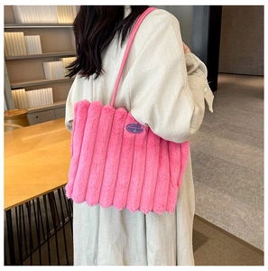 Detail of rose pink plush tote bag with vertical stripes and fashion label patch