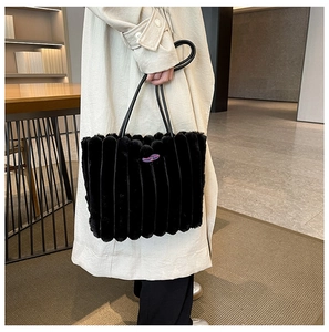 Detail of plush black tote bag with vertical stripes and high-capacity winter design