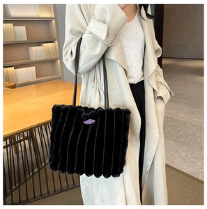 Detailed texture of black faux fur tote bag with vertical stripes and fashion girl label