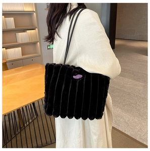 Detail of black plush tote bag with vertical stripes and Fashion Girl logo on shoulder