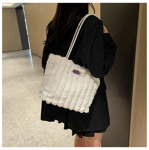 Detail of white plush tote bag with vertical stripes and Fashion Girl logo plaque