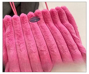 Detail of bright pink plush tote bag featuring vertical stripes and leather fashion tag