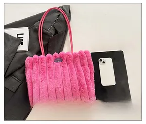 Close-up of pink plush tote bag with vertical stripes and cherry logo patch