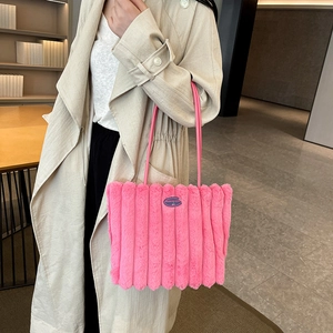 Plush pink striped tote bag with cherry patch shown on a stylish trench coat model