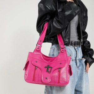 Sac fourre-tout punk rose avec croix en métal et clous porté par un mannequin