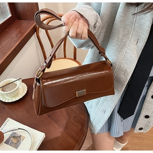 Detail of vintage coffee brown baguette bag with oil wax finish and metallic clasp