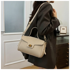 Détail d'un sac en cuir beige clair à motif lychee avec fermoir doré élégant
