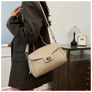 Détail d'un sac à main en cuir beige crème avec un fermoir rotatif en métal vintage