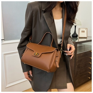 Détail du sac à main en cuir marron grainé avec fermoir rotatif doré de style vintage
